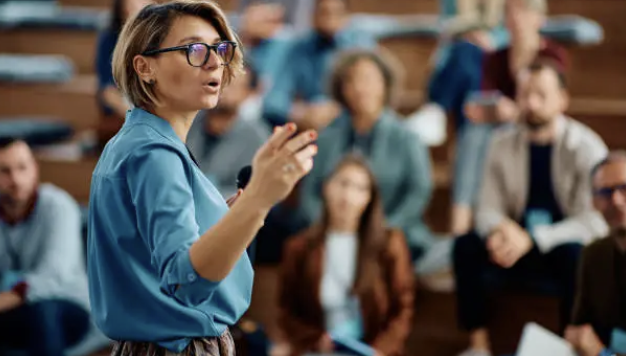 Professional speaking to an engaged audience in a lecture hall setting